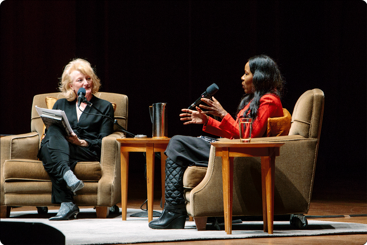 A gif of six alternating images. Image 1: A young person standing in front of a podium on stage at Benaroya Hall. Image 2: Krista Tippett and Isabel Wilkerson seated on stage during a live conversation at Benaroya Hall. Image 3: The audience seated at Benaroya Hall in Seattle. One seated audience member raises their hands in applause. Image 4: Rebecca Hoogs, the Executive Director of Seattle Arts & Lectures, standing before a podium on stage at Benaroya Hall. Image 5: Isabel Wilkerson and Krista Tippett standing side by side. Image 6: The audience seated at the live conversation between Isabel Wilkerson and Krista Tippett at Benaroya Hall.